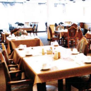 An empty restaurant with neatly arranged tables and chairs.