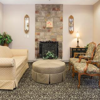 A cozy living room setting featuring comfortable seating, a decorative fireplace, and subtle home decor.