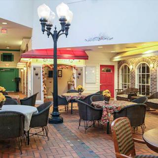 A cozy indoor cafe setting with tables, chairs, and a streetlamp under warm lighting.