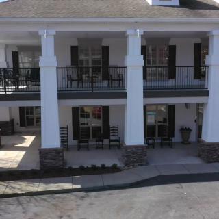 A two-story building with balconies and large columns.