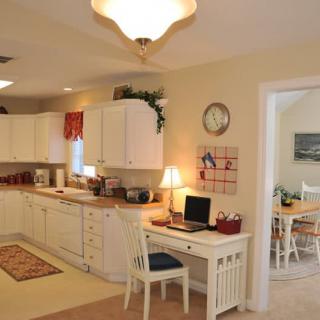 A cozy kitchen with an adjacent home office space and warm lighting.