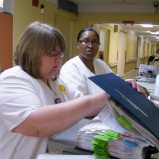 Two nurses reviewing medical documents at a hospital.