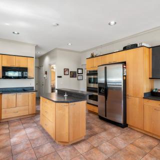 A modern kitchen featuring wood cabinets, stainless steel appliances, and a central island.