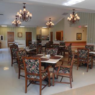 A cozy dining area featuring floral-patterned chairs and elegant chandeliers, perfect for communal meals.