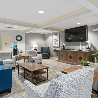 A modern waiting room with comfortable seating and a large TV.