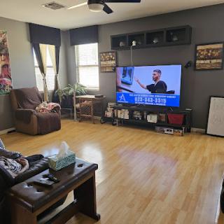 A cozy living room with a large TV and comfortable seating.