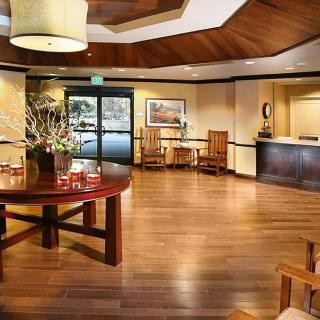 A warmly lit hotel lobby with wood flooring and elegant furnishings.