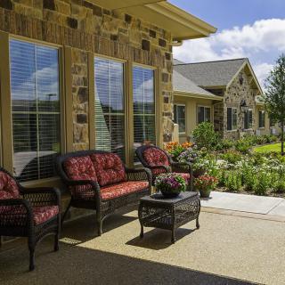 A cozy patio with outdoor seating and a beautifully landscaped garden on a sunny day.