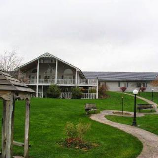 A serene outdoor view featuring a modern building surrounded by lush green grass and winding pathways.