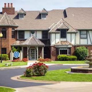 A large residential building with a landscaped garden and driveway.