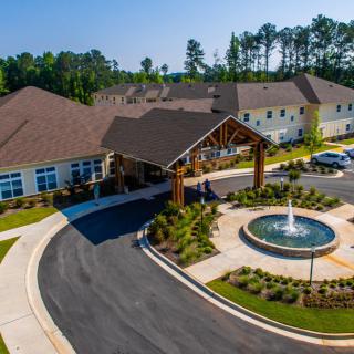 Aerial view of a residential building with a circular driveway and fountain.