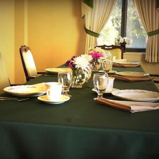 An elegantly set dining table with floral centerpiece in a restaurant.