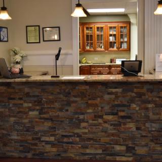 A reception desk with a stone facade in an office setting.