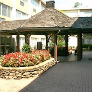 An outdoor gazebo surrounded by landscaped gardens with vibrant flowers.