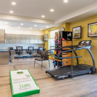 A modern fitness and recreation area featuring a treadmill and seating arrangements.
