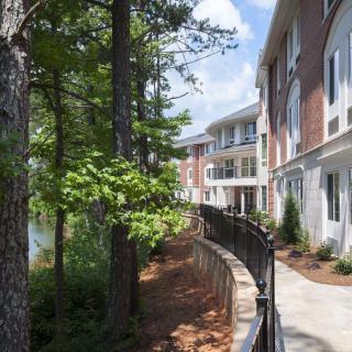 A peaceful walkway next to a modern building, surrounded by trees.