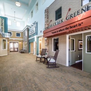A modern indoor hallway designed to resemble a storefront street, complete with seating areas.