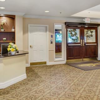 A hotel lobby with a reception area and entrance doors.