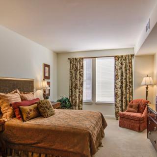 A cozy bedroom with warm decor and comfortable furnishings.