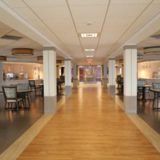 A spacious, modern hallway with seating areas and wooden flooring in a commercial building.
