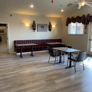 A spacious and bright dining area with a mix of booth seating and tables.