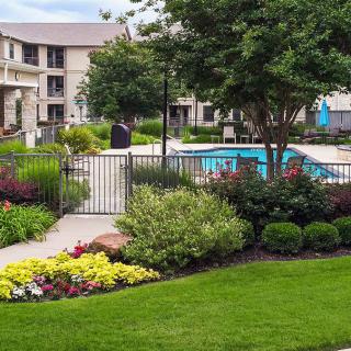 A well-maintained apartment complex with landscaped gardens and a swimming pool.