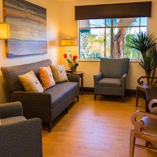 A cozy living room with a sofa, armchairs, and decorative elements enhancing a warm atmosphere.
