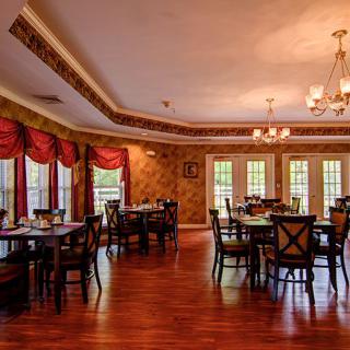 An elegantly decorated dining room with tables and chairs set for guests.