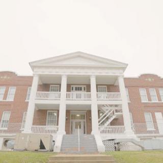 A stately building featuring classical architecture with prominent columns and a welcoming front entrance.