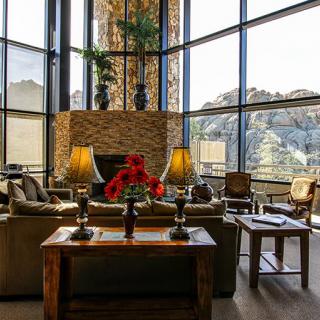 A modern living room featuring large windows with a mountain view and elegant interior design.