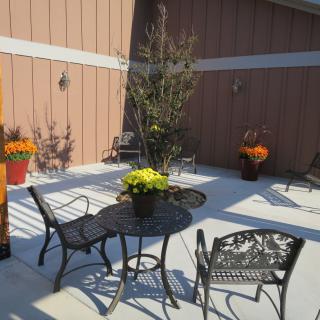 A sunny outdoor patio area with metal furniture and potted plants.