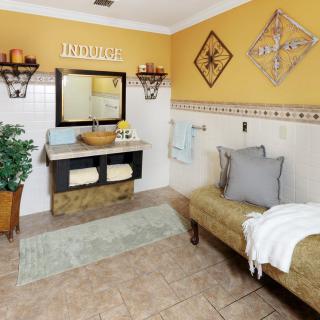 A cozy bathroom with warm colors, featuring a stylish sink, mirror, and decorative wall art.