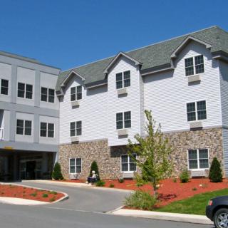 A sunny day view of a residential building with landscaped surroundings.