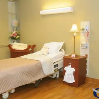 A clean and well-organized hospital room with a single patient bed and cozy decor.