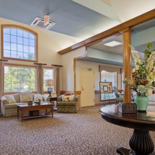 A cozy lobby area with comfortable seating and decorative flowers.