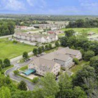 Aerial view of a suburban residential area surrounded by greenery.