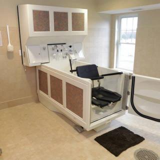 An accessible bathtub with a door and seat for easy entry in a modern bathroom.