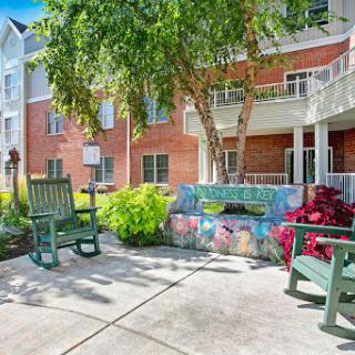 A cozy outdoor seating area surrounded by lush greenery and colorful flowers, perfect for relaxation.