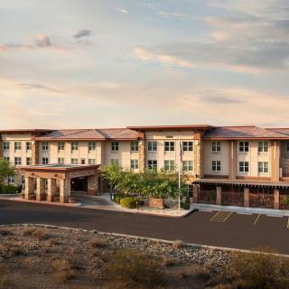 A scenic view of a desert hotel under a cloudy sky.