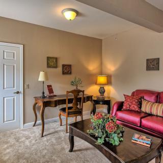 A cozy living room with a vibrant red sofa, elegant wooden furniture, and tasteful decor.