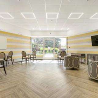 A modern meeting room with ample natural light from a large window.