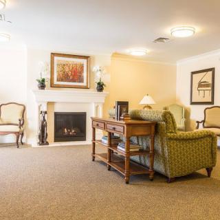 A cozy living room featuring a fireplace, elegant armchairs, and classic decor.