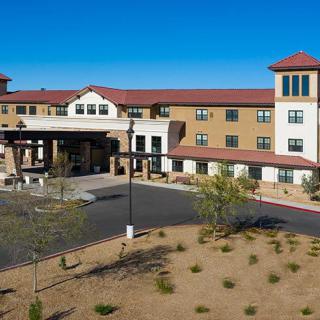 Exterior view of a large, multi-story building with desert landscaping.
