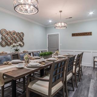 Elegant dining room with modern decor and chandeliers.