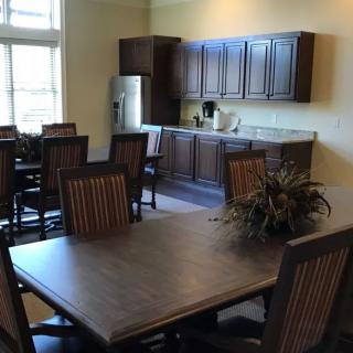 A spacious kitchen and dining area with wooden furniture and modern appliances.