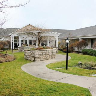 A scenic view of a building with a surrounding garden and pathway.