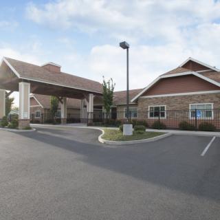 A healthcare facility with a covered entrance and adjacent parking lot.
