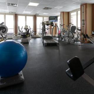 A well-equipped gym featuring treadmills, stationary bikes, and a variety of exercise equipment.