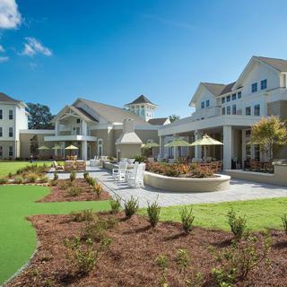 A modern building with well-maintained landscaping under a clear blue sky.