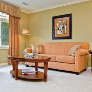 A cozy living room with a peach sofa, stylish coffee table, and decorative artwork.